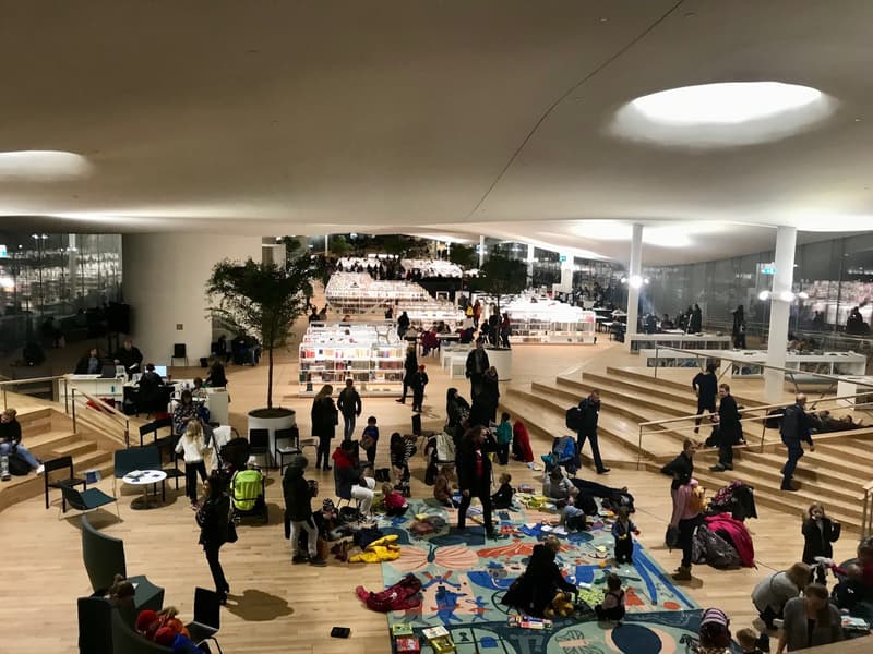 View from north to south, across Oodi's children's section. Families spending a Friday evening at Oodi.